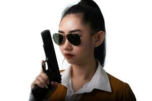 ritratto bella donna asia che indossa un abito giallo una mano che tiene pistola pistola sullo sfondo bianco foto