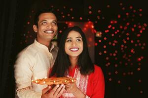 bellissimo indiano coppia Tenere diya thali per Diwali celebrazione foto