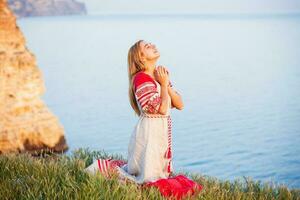 donna indossare tradizionale russo Abiti appassionatamente preghiere su un' mare riva foto