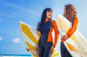 surfer ragazze discutere qualcosa e sorridente foto