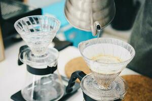 mano gocciolare caffè, barista fabbricazione infuso caffè di scrosciante acqua su terra caffè con filtro. foto