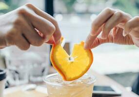 umano mani strappo un' pezzo di arancia. foto