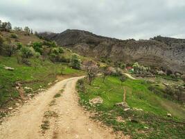 sporco strada per un' lontano montagna villaggio. primavera Visualizza di città su il roccia. autentico daghestan montagna villaggio gunib. foto