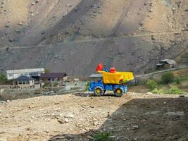 giallo giocattolo cumulo di rifiuti camion. minerale estrazione, opera nel il montagne concetto. foto