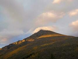 montagna paesaggio con roccia nel bellissimo d'oro tramonto. natura sfondo di roccioso montagna parete con acuto roccia e verde foresta. colorato alba fondale con alto roccioso montagna. foto