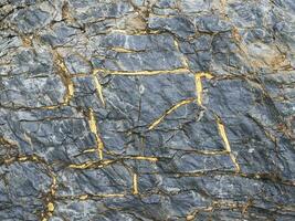 venato d'oro calcolo, un' naturale minerale strutturato vivido geologica sfondo con maleducato pietre. sorprendente minerale. pezzo di roccia. foto
