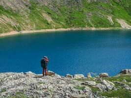 viaggio fotografo prendere un' immagine di il lontano montagna turchese lago a partire dal alto montagne.viaggio libero professionista blogger stile di vita, concetto avventura viaggio all'aperto. foto