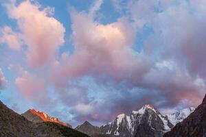 roccioso montagna nel alba nuvoloso cielo. atmosferico minimo montagna scenario con lilla alba cielo. panoramico minimalista paesaggio con viola tramonto nel montagne. foto
