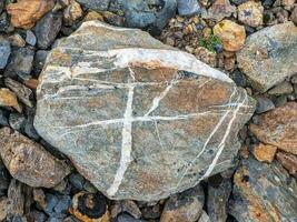 venato di bianco calcolo, un' naturale minerale strutturato vivido geologica sfondo con maleducato pietre. sorprendente minerale. pezzo di roccia. foto