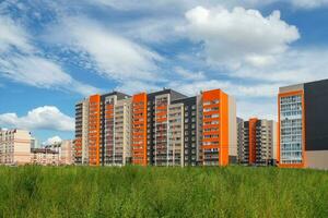 moderno costruzione, nuovo quartiere. bellissimo nuovo edifici. colorato parete su il sfondo di blu nuvoloso cielo. copia spazio. foto