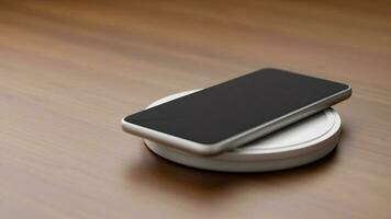 mobile Telefono ricarica batteria con senza fili caricabatterie su Lavorando tavolo. foto