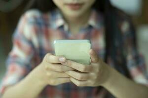 vicino su giovane asiatico donna utilizzando mobile Telefono. foto