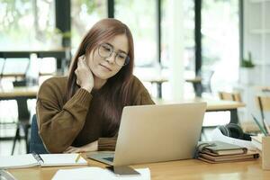 giovane donna studiando o Lavorando in linea utilizzando il computer portatile. foto