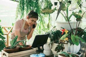 giovane donna pianta negozio proprietario è controllo cliente ordine a partire dal sito web foto