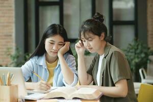 giovane asiatico studenti città universitaria aiuta amico attraente su e apprendimento. foto