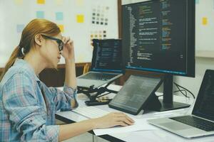 giovane donna copertura sua viso con il fatica di opera codifica e programmazione Software. foto