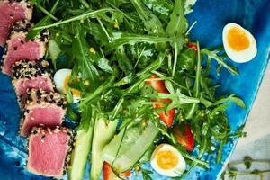 tonno con insalata e verdure sul piatto blu foto
