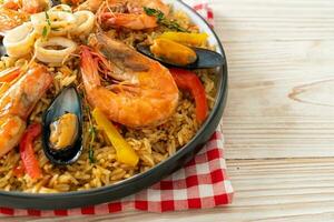 paella di mare con gamberi, vongole, cozze su riso allo zafferano foto