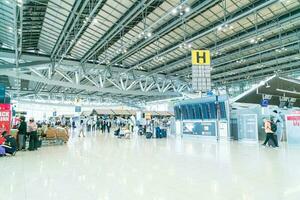 bangkok, tailandia - 23 maggio 2022 - passeggeri dell'aeroporto di bangkok suvarnabhumi all'interno del terminal di partenza, persone con maschere mediche da coronavirus. foto