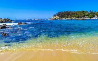 spiaggia sabbia blu turchese acqua onde rocce panorama puerto escondido. foto