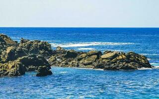 spiaggia sabbia blu turchese acqua onde rocce panorama puerto escondido. foto