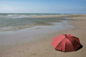 panoramico Visualizza rosso ombrello su il spiaggia foto