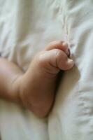 carino piedi di un' neonato bambino su un' bianca materasso foto