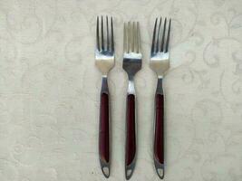 parecchi Vintage ▾ forchette disposte in modo univoco su il tavolo foto