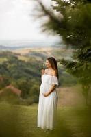 giovane donna incinta nella foresta foto