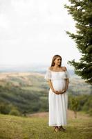 giovane donna incinta nella foresta foto