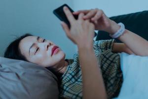 donna sdraiata sul divano utilizzando il telefono cellulare foto