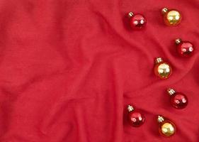palle di Natale rosse e oro su sfondo rosso tessile