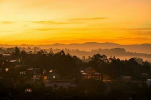 un' ipnotizzante Visualizza di il alto colline su un' nebbioso giorno a tramonto foto