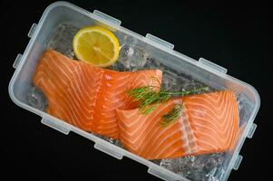 salmone filetto con Limone erba e spezie, fresco crudo salmone pesce su ghiaccio per cucinando cibo frutti di mare salmone pesce nel plastica scatola foto