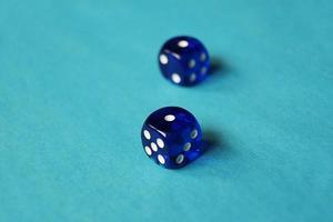 Una vibrante macro monocromatica con profondità di campo circa due dadi da gioco in vetro blu con due sfortunati numero uno su sfondo blu foto