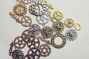 una macro piatta steampunk e antica su macchinari fatti di ingranaggi in bronzo argento e oro a forma di cuore con sfondo beige foto