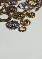 una macro steampunk e antica sui macchinari fatti di ingranaggi in bronzo, argento e oro con sfondo beige foto