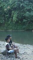 gorontalo-indonesia, Maggio 2023 - giovane uomo godendo il mattina atmosfera di il sul fiume foto