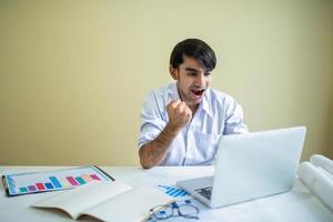 uomo d'affari che lavora con laptop e documenti foto