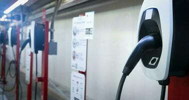 elettrico auto ricarica stazione per caricare ev batteria. spina per elettrico veicolo. ev caricabatterie. ricarica punto a auto parcheggio lotto di il centro commerciale. pulito e sostenibile energia. commerciale ev ricarica punto. foto