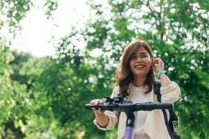 ritratto di giovane asiatico donna equitazione un' bicicletta nel il parco foto