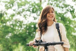 ritratto di un' giovane donna equitazione un' bicicletta nel il parco. foto