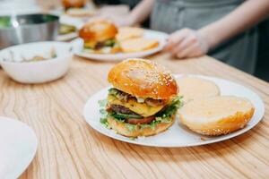 hamburger con Manzo e verdure. vicino su. delizioso hamburger nel un' cucinando classe. hamburger con mirtillo salsa e hamburger con cipolla salsa. foto