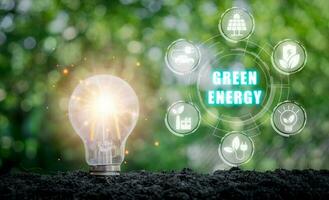 verde energia concetto, leggero lampadina su suolo con verde energia icona su virtuale schermo, ambientale tecnologia, circolare economia. foto