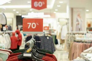 selettivo messa a fuoco per rosso sconto tavola con 70 per cento scrivere. per sconto modelli per Da donna e Uomini capi di abbigliamento a il centro commerciale. morbido messa a fuoco foto