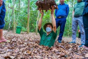 il cu chi tunnel. un' guida dimostrando Come un' vietcong nascondere in il tunnel. è Usato nel Vietnam guerra. famoso turista attrazione nel Vietnam. azione foto