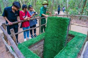 il cu chi tunnel. il personale mostrando uso il trappola nel cu chi tunnel. è Usato nel Vietnam guerra. famoso turista attrazione nel Vietnam. azione foto