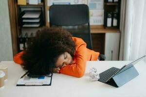 africano attività commerciale donna è stressato, annoiato, e troppi pensieri a partire dal Lavorando su un' tavoletta a il ufficio. foto