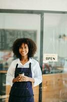 avviare riuscito piccolo attività commerciale proprietario pmi africano donna In piedi con tavoletta nel bar ristorante. donna barista bar proprietario. foto