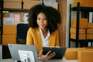 piccolo attività commerciale imprenditore pmi libero professionista donna Lavorando a casa ufficio, scatola, tavoletta e il computer portatile in linea, marketing, confezione, consegna, e-commerce concetto foto